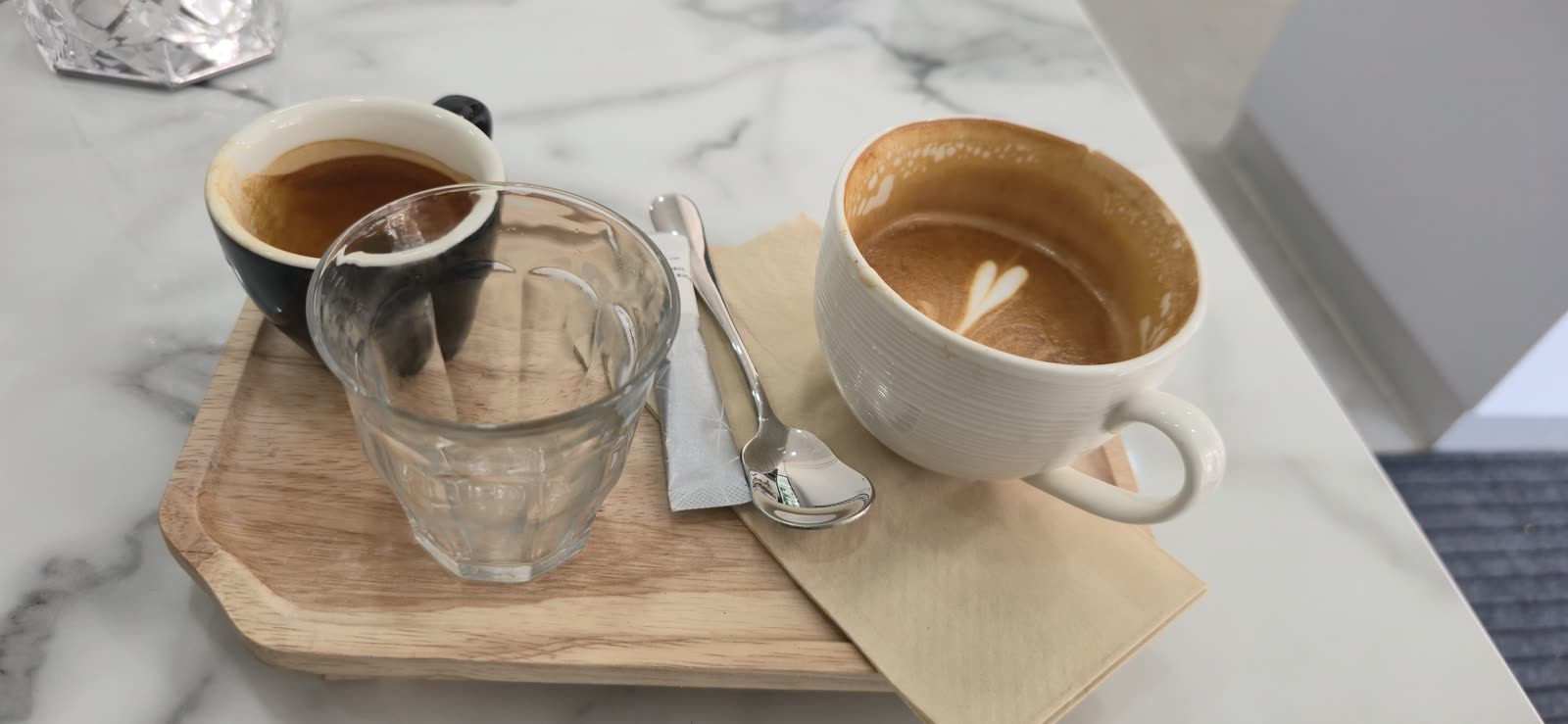espresso cup and water glass on a marble cafe counter